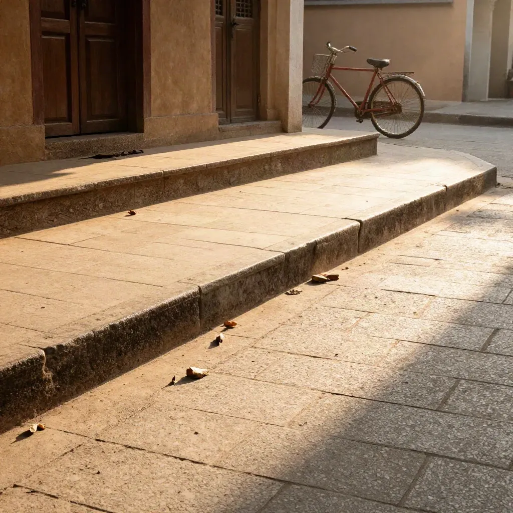 Elevated view of a temple-side street with long morning shadows, pale paving, and dry leaves.